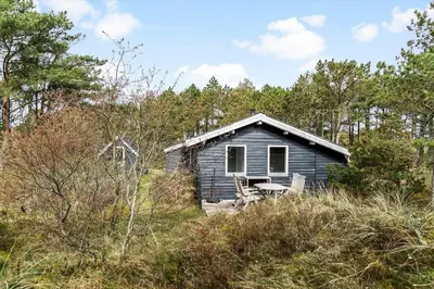 a small blue house in the middle of a field at 1315-Thisted-Sandtornvej-15 in Thisted
