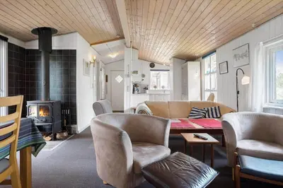 a living room with a table and chairs and a fireplace at 619-Thisted-Blabaervej-32 in Thisted
