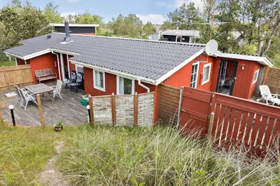 a red house with a deck and a fence at 619-Thisted-Blabaervej-32 in Thisted