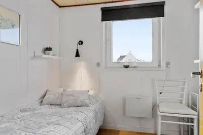 a bedroom with a bed and a window and a chair at 271-Thisted-Nordsovej-88 in Thisted
