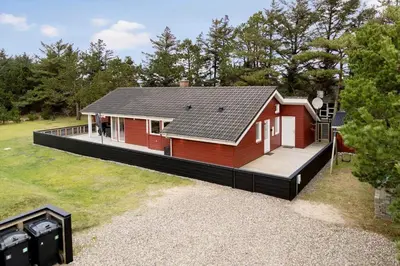 a red house with a deck in a yard at 854-Thisted-Molgaardsvej-3 in Thisted