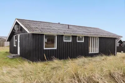 a black house sitting in the middle of a field at 882-Thisted-Nordsovej-100 in Thisted