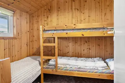a room with two bunk beds in a wooden wall at 646-Thisted-Bredkaervej-43 in Thisted