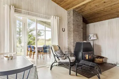 a living room with a fireplace and a table and chairs at 215-Thisted-Tunvej-29 in Thisted
