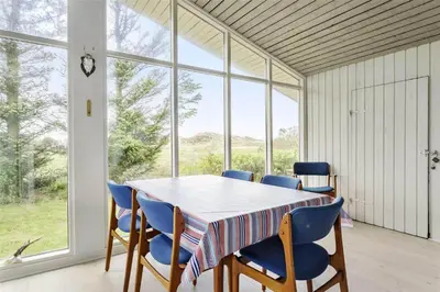 a table and chairs in a room with a large window at 215-Thisted-Tunvej-29 in Thisted