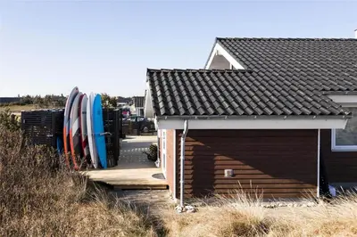 a building with surfboards next to a house at 951-Thisted-Bavnbak-39 in Torsted