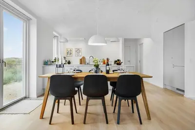 a kitchen with a wooden table and chairs at 1305-Snedsted-Klitfogedvej-5 in Snedsted