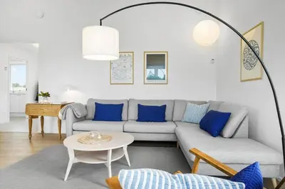 a living room with a gray couch and blue pillows at 1305-Snedsted-Klitfogedvej-5 in Snedsted