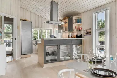 a kitchen with a table and chairs and windows at 866-Thisted-Klemsvej-35 in Thisted
