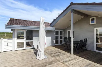 a patio with a table and an umbrella on a house at 928-Thisted-Kobbelsti-15 in Torsted