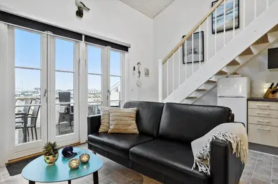 a living room with a black couch and a table at 254-Vestervig-Havnevej-1-lejl-4 in Vestervig