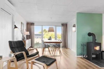 a living room with a table and chairs and a fireplace at 572-Thisted-Kristinesvej-7 in Thisted