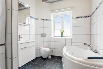 a bathroom with a tub and a toilet and a sink at 125-Thisted-Fiskervej-7 in Thisted