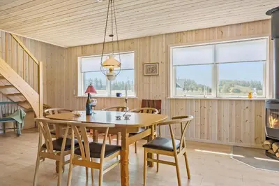 a dining room with a table and chairs and a fireplace at 1051-Thisted-Skjaerbakken-57 in Torsted