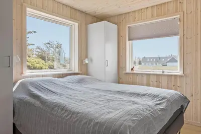 a bedroom with a bed and two windows at 1051-Thisted-Skjaerbakken-57 in Torsted