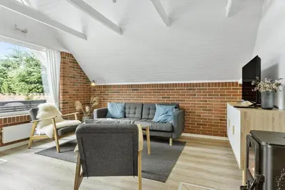 a living room with a couch and a brick wall at 479-Thisted-Kristinesvej-36 in Thisted