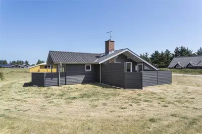 a small house in a field next to a house at 533-Thisted-Fiskervej-153 in Thisted