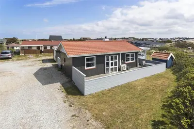 a small house with a red roof on a yard at 581-Thisted-Nordsovej-32 in Thisted