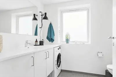 a white bathroom with a sink and a washing machine at 556-Thisted-Havstokken-24-A in Thisted