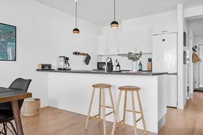 a kitchen with white cabinets and two bar stools at 556-Thisted-Havstokken-24-A in Thisted