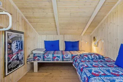 a bedroom with a bed with blue pillows at 796-Snedsted-Somaerkevej-66 in Snedsted