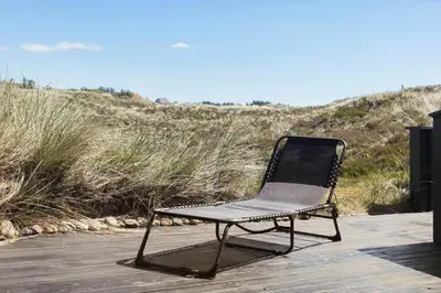 a black chair sitting on a boardwalk near the beach at 796-Snedsted-Somaerkevej-66 in Snedsted