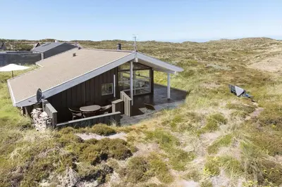 a house on the side of a hill with a deck at 796-Snedsted-Somaerkevej-66 in Snedsted