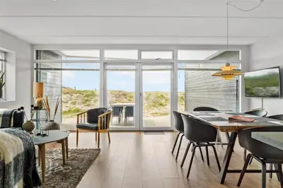 a living room with a dining room table with a view of the ocean at 785-Thisted-Havstokken-32-A in Thisted