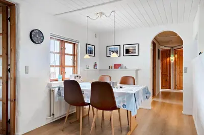 a dining room with a table with chairs and a clock at 787-Thisted-Nordsovej-38 in Thisted