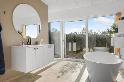 a bathroom with a white tub and a mirror at 109-Thisted-Lyngbakken-9 in Thisted