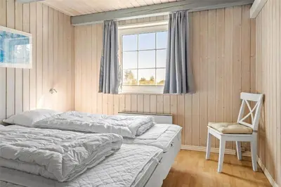 a bedroom with two beds and a chair and a window at 517-Thisted-Sigvej-10 in Thisted
