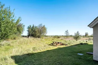 a picnic table in a field next to a house at 517-Thisted-Sigvej-10 in Thisted