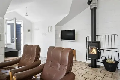 a living room with leather chairs and a fireplace at 542-Thisted-Kuttervej-11 in Thisted