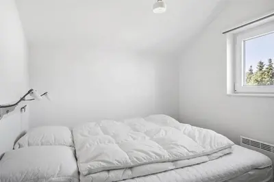 a white bed in a white room with a window at 542-Thisted-Kuttervej-11 in Thisted
