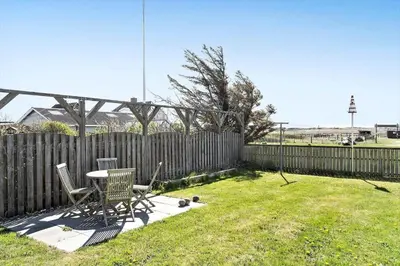 a backyard with a table and chairs and a fence at 758-Vestervig-Vesterhavsvej-28 in Vestervig