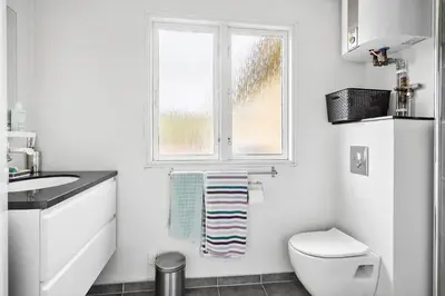 a white bathroom with a toilet and a window at 162-Thisted-Molgaardsvej-62 in Thisted