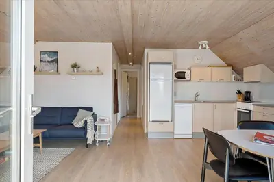 a living room with a blue couch and a kitchen at 716-Thisted-Kristinesvej-34 in Thisted