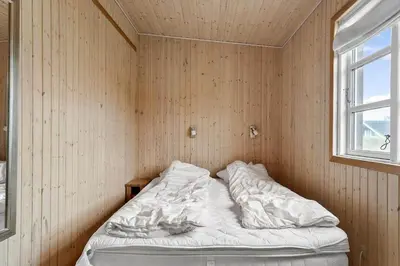 a bed in a corner of a room with a window at 529-Thisted-Nordsovej-24 in Thisted