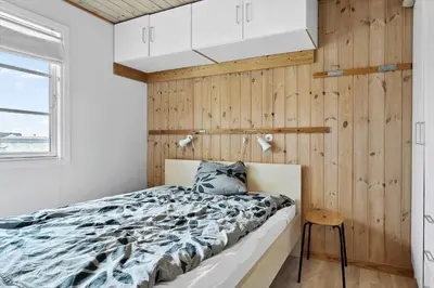 a bedroom with a bed and a wooden wall at 529-Thisted-Nordsovej-24 in Thisted