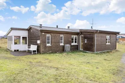 a small wooden house with a chair in a field at 529-Thisted-Nordsovej-24 in Thisted