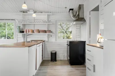 a kitchen with white cabinets and a black refrigerator at 567-Thisted-Fiskervej-67 in Thisted