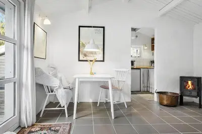 a living room with a table and a fireplace at 1309-Thisted-Blabaervej-2 in Thisted