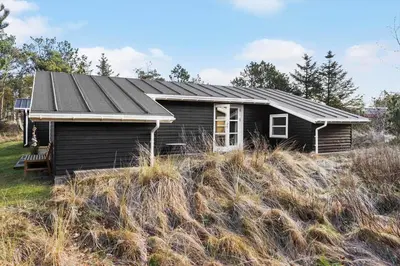 a black house on a hill in a field at 1309-Thisted-Blabaervej-2 in Thisted