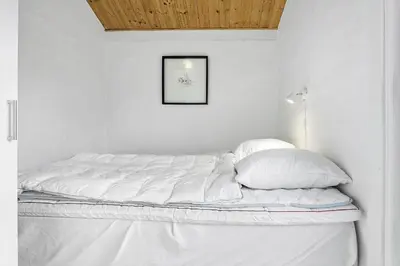 a bed with white sheets and pillows in a room at 1309-Thisted-Blabaervej-2 in Thisted