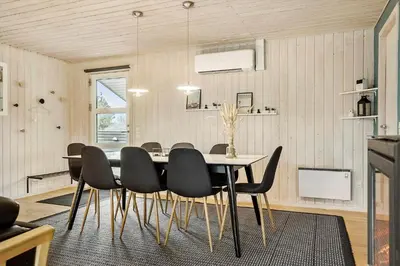 a dining room with a table and black chairs at 1322-Snedsted-Lykkens-Hab-21 in Snedsted