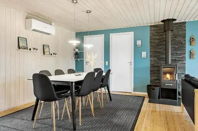 a dining room with a table and chairs and a fireplace at 1322-Snedsted-Lykkens-Hab-21 in Snedsted