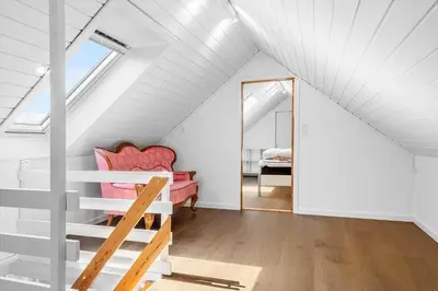 a attic room with a red couch and a mirror at 1329-Thisted-Nordsovej-226 in Thisted