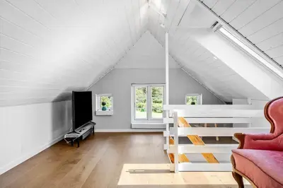 a attic room with a bed and a couch at 1329-Thisted-Nordsovej-226 in Thisted