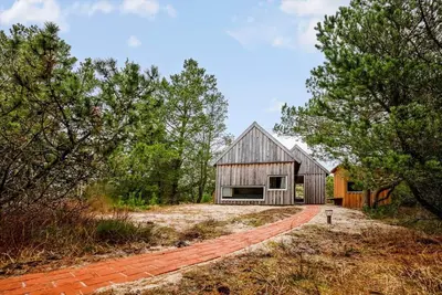 a barn conversion with a brick driveway and trees at 1061-Thisted-Spanggardsvej-85-B in Torsted
