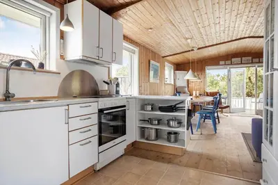 a kitchen with white cabinets and a dining room at 1336-Thisted-Nordsovej-50 in Thisted